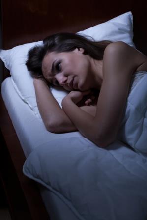 Woman lying awake in bed at night