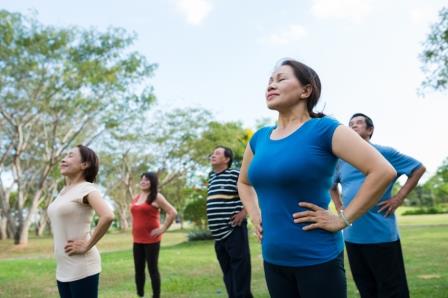Vietnamese senior people practicing breathing exercise outdoors
