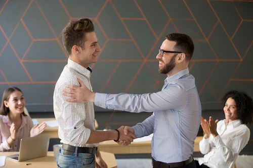 Team leader handshaking employee congratulating with professional achievement or promotion